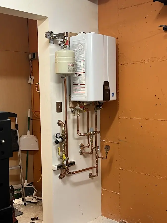 Plumbing technician inspecting water heater connections in Todd Creek